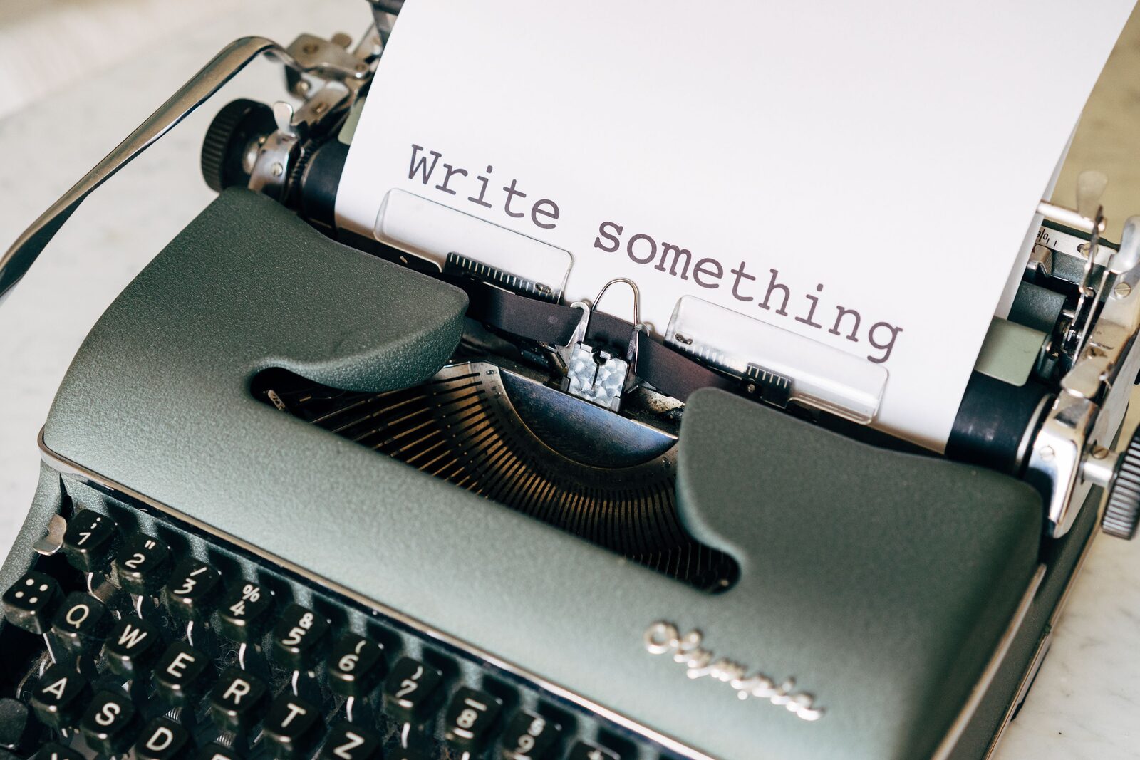 ماشین تحریر قدیمی با عبارت Write something روی کاغذ